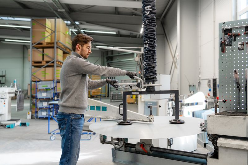 Präzises Einlegen: Mit einer Sondertraverse und dem Lightlift 30 kg werden großformatige Blechscheiben kontrolliert in den Kreisschneider eingebracht.  (Bild: Timmer GmbH)