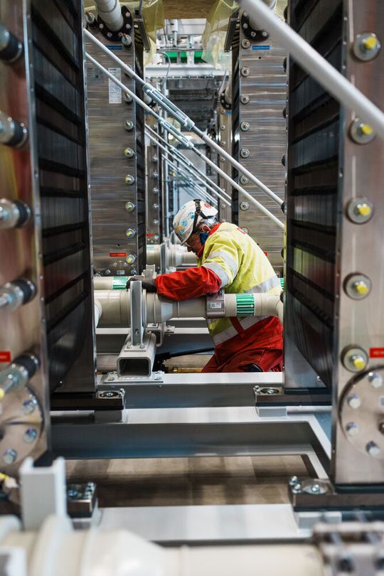 Die letzten Zentimeter sind Handarbeit: Monteure verbinden die einzelnen Elektrolyseur-Module miteinander. Bei Fertigstellung werden insgesamt 72 „Stacks“ eine Kapazität von 54 Megawatt haben.(Bild:  BASF)