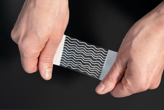 Das Material besteht aus drei Schichten: einer Polymerfolie aus Polyurethanacrylat, einer 3D-gedruckten wellenförmigen Metastruktur und elektrogesponnenem Kollagen. Zusammen bilden sie die mechanischen und biologischen Eigenschaften natürlichen Gewebes nach.(Bild:  Fraunhofer IAP)