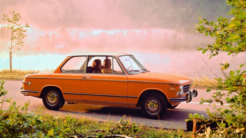 Bayerisches Stilleben in den Siebzigen: Die BMW 02-Reihe erschloss ab 1966 erfolgreich die Marktnische der kompakten zweitürigen Sportlimousine und wurde ab 1975 vom 3er ersetzt, aber noch bis 1977 gebaut. Insgesamt entstanden über 861.000 Stück der kompakten Limousine. Selbst eine Elektrovariante gab es. Die hatte BMW für die Olympischen Sommerspiele 1972 als Begleitfahrzeug der Langstreckengeher und Marathonläufer während der Spiele  entwickelt. Beim zweiten Versuchsträger bestand der Energiespeicher aus einem 350 Kilogramm schweren Paket mit zwölf Blei-Starterbatterien unter der Motorhaube, das gegen ein Paket geladener Batterien getauscht werden konnte. Damit konnte man bei konstant 50 km/h etwa 60 Kilometer weit fahren, im Stadtverkehr waren es etwa 30 Kilometer Reichweite. (Bild: BMW AG)
