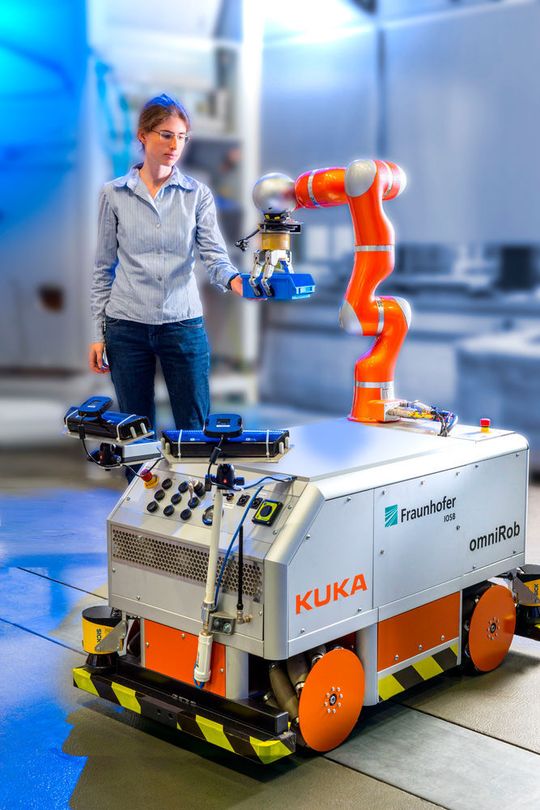 Durch die multisensorielle Arbeitsraumüberwachung kann die Mitarbeiterin sicher mit dem Roboter interagieren. Durch die multisensorielle Arbeitsraumüberwachung kann die Mitarbeiterin sicher mit dem Roboter interagieren.