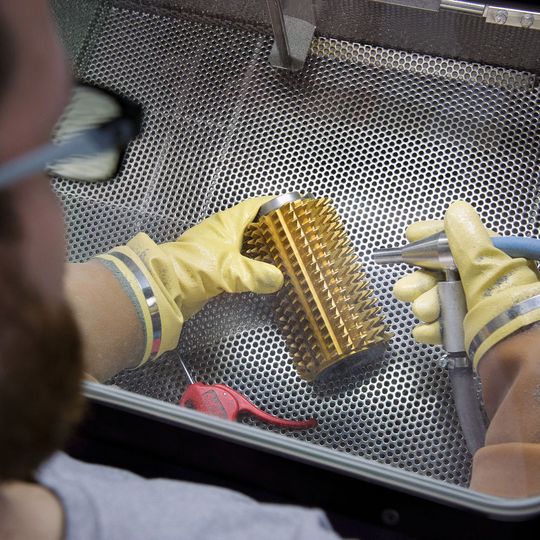 Glänzende Oberflächen können jetzt auch strahltechnisch hergestellt werden: Auf der innovativen «PolishPeen»-Anlage. Das Bild zeigt den Prozess des Polierstrahlens. Glänzende Oberflächen können jetzt auch strahltechnisch hergestellt werden: Auf der innovativen «PolishPeen»-Anlage. Das Bild zeigt den Prozess des Polierstrahlens.