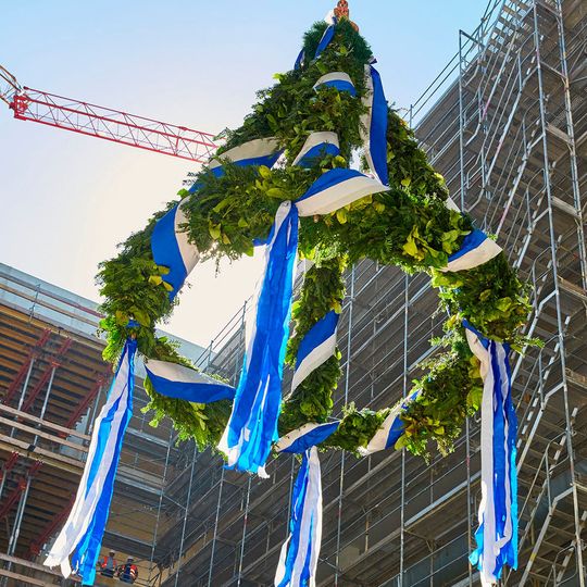 Bei bestem Wetter schwebt die Richtkrone im Atrium des neuen Labor- und Bürogebäudes empor. Bei bestem Wetter schwebt die Richtkrone im Atrium des neuen Labor- und Bürogebäudes empor.