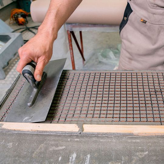 Im Otto-Mohr-Laboratorium der TU Dresden wird Feinbeton in einer dünnen Lage (dünner als 5 mm) auf eine Schalung aufgetragen. In diese Schicht wird ein Carbongelege eingelegt und mit einer Kelle leicht eingearbeitet. Anschließend wird das Gelege mit einer weiteren Schicht Feinbeton überdeckt. Der Vorgang wird so oft wiederholt bis die gewünschte Lagenanzahl erreicht ist (meist 2 bis 4 Lagen). Im Otto-Mohr-Laboratorium der TU Dresden wird Feinbeton in einer dünnen Lage (dünner als 5 mm) auf eine Schalung aufgetragen. In diese Schicht wird ein Carbongelege eingelegt und mit einer Kelle leicht eingearbeitet. Anschließend wird das Gelege mit einer weiteren Schicht Feinbeton überdeckt. Der Vorgang wird so oft wiederholt bis die gewünschte Lagenanzahl erreicht ist (meist 2 bis 4 Lagen).