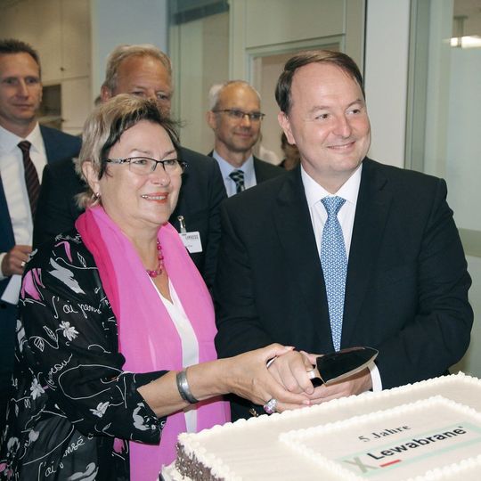 Petra Wust, Oberbürgermeisterin der Stadt Bitterfeld-Wolfen, schneidet mit Jean-Marc Vesselle, Leiter des Geschäftsbereichs LPT, die Geburtstagstorte an und gratuliert. Petra Wust, Oberbürgermeisterin der Stadt Bitterfeld-Wolfen, schneidet mit Jean-Marc Vesselle, Leiter des Geschäftsbereichs LPT, die Geburtstagstorte an und gratuliert.