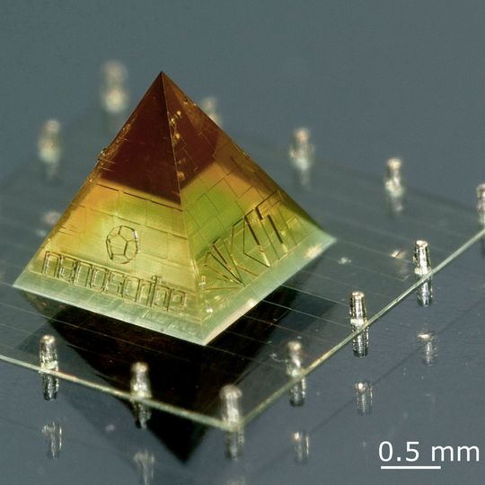 Auf den Seitenflächen dieser 3D-gedruckten Miniatur der Karlsruher Pyramide befinden sich die Logos von HeKKSaGOn, des KIT und Nanoscribe. Sie hat eine Gesamthöhe von nur 2 mm. Auf den Seitenflächen dieser 3D-gedruckten Miniatur der Karlsruher Pyramide befinden sich die Logos von HeKKSaGOn, des KIT und Nanoscribe. Sie hat eine Gesamthöhe von nur 2 mm.