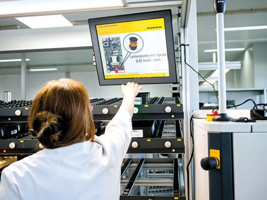 Mit einem Pick-to-Light-System zeigt ein Display bei Turck die Hinweise zum Einsetzen des nächsten Bauteils, die Sensorleuchte zeigt dessen Lagerplatz im Regalsystem. Mit einem Pick-to-Light-System zeigt ein Display bei Turck die Hinweise zum Einsetzen des nächsten Bauteils, die Sensorleuchte zeigt dessen Lagerplatz im Regalsystem.