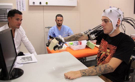 Das hirngesteuerte Hand-Exoskelett ermöglicht es, die gelähmte Hand im Alltag wieder zu nutzen: Dr. Surjo R. Soekadar (links) im Test mit einem Probanden. Das hirngesteuerte Hand-Exoskelett ermöglicht es, die gelähmte Hand im Alltag wieder zu nutzen: Dr. Surjo R. Soekadar (links) im Test mit einem Probanden.