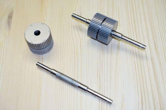 Im oberen Bildbereich ist eine Rotorwelle komplett dargestellt. Die losen Rotorpakete stehen in Bildmitte und unten eine Welle. Deutlich ist der aufgeraute Bereich von der glatten Oberfläche zu unterscheiden.