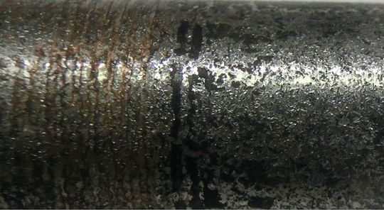 Die aufgeraute Wellenoberfläche mit einigen bräunlichen Rasträndern, die ganz wenig Klebstoff zeigen und dunklere Spuren, die „verbrannte“ Klebstoffreste darstellen können.