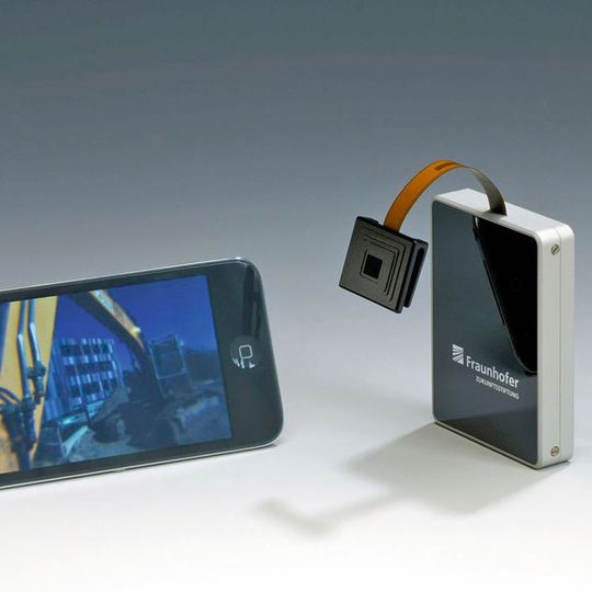 Der erste Prototyp der neuen Technik des Fraunhofer-IOF überträgt die Bilder der Kamera noch via Bluetooth über eine Sendebox an das Smartphone. Der erste Prototyp der neuen Technik des Fraunhofer-IOF überträgt die Bilder der Kamera noch via Bluetooth über eine Sendebox an das Smartphone.