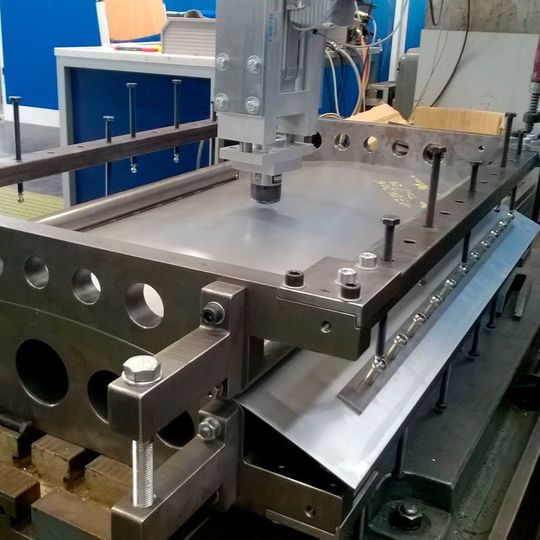 Vorrichtung zur Vorspannung einachsig gekrümmter paraboloider Versuchsteile auf Sollform mit konstantem Krümmungsradius von 860 mm, aufgebaut auf dem Beulprüfstand am ZUK. Vorrichtung zur Vorspannung einachsig gekrümmter paraboloider Versuchsteile auf Sollform mit konstantem Krümmungsradius von 860 mm, aufgebaut auf dem Beulprüfstand am ZUK.