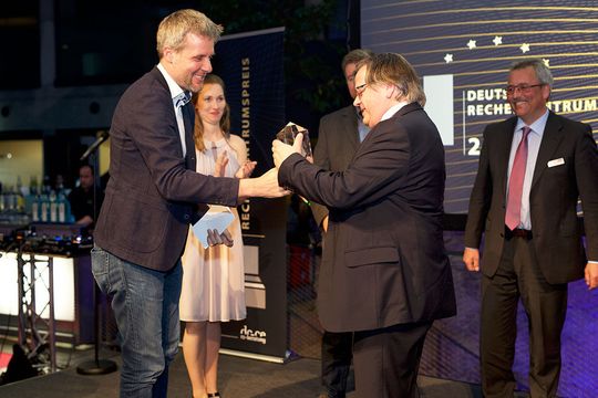 MdB Dieter Janecek übergibt den Deutschen Rechenzentrumspreis an Rudolf Lohner vom Karlsruher Institut für Technologie (KIT) für das Projekt „ForHLR – Hocheffizientes HPC-Rechenzentrum mit Warmwasserkühlung“.