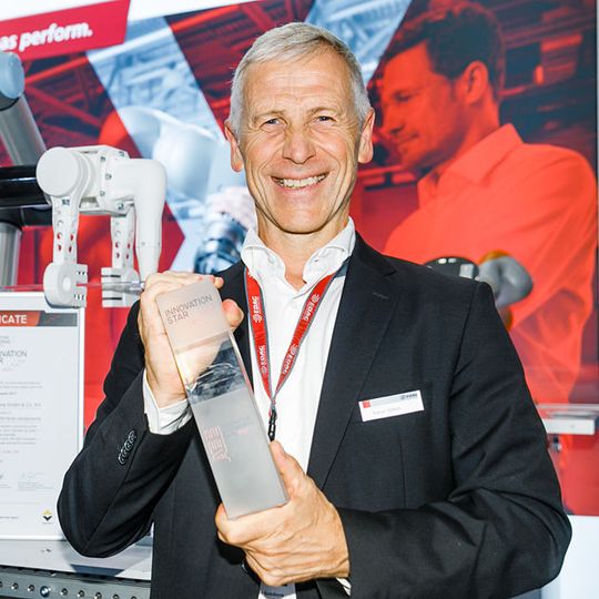 Rainer Wittich, Geschäftsführer der EDAG Production Solutions, mit dem AEE Innovation Award 2017 auf dem EDAG PS-Messestand. Im Hintergrund sichtbar ist das ausgezeichnete Greifsystem. Rainer Wittich, Geschäftsführer der EDAG Production Solutions, mit dem AEE Innovation Award 2017 auf dem EDAG PS-Messestand. Im Hintergrund sichtbar ist das ausgezeichnete Greifsystem.