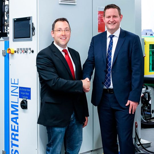 Dominik Malecha, Bereichsleiter Oberflächentechnik Formteile beim Kunststoff-Institut Lüdenscheid (l.), und Alexander Frank, Vertriebsingenieur bei Hennecke, bei der Übergabe der neuen Dosieranlage. Dominik Malecha, Bereichsleiter Oberflächentechnik Formteile beim Kunststoff-Institut Lüdenscheid (l.), und Alexander Frank, Vertriebsingenieur bei Hennecke, bei der Übergabe der neuen Dosieranlage.
