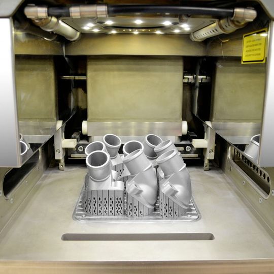 Im Bauraum des Laserdruckers ist erstmals eine metallische Thermostatabdeckung durch selektives Laserschmelzen (SLM) entstanden. Im Bauraum des Laserdruckers ist erstmals eine metallische Thermostatabdeckung durch selektives Laserschmelzen (SLM) entstanden.