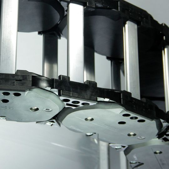 Bei einer Innenhöhe von 87 mm lässt sich die Breite der Energieführungskette mit Aluminiumstegen im 1-mm-Raster dem Bauraum anpassen. Bei einer Innenhöhe von 87 mm lässt sich die Breite der Energieführungskette mit Aluminiumstegen im 1-mm-Raster dem Bauraum anpassen.