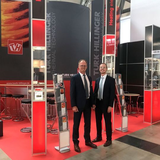 Türk + Hillinger's CEO Michael Mann with son Hendrik at the company's booth at Fakuma 2017. Türk + Hillinger's CEO Michael Mann with son Hendrik at the company's booth at Fakuma 2017.
