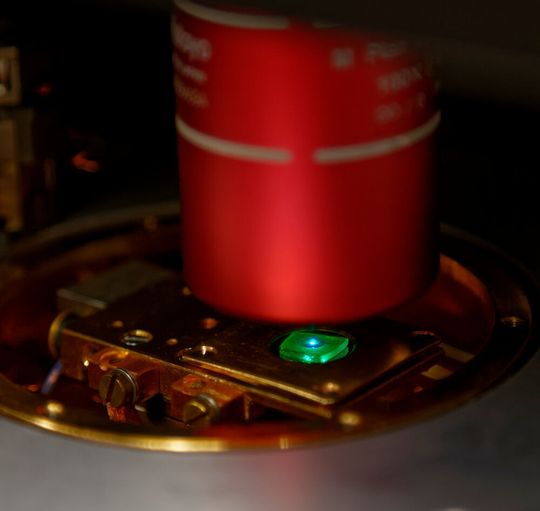 Eine Probe mit mehreren grün leuchtenden Perowskit-Quantenpunkten, die von einem blauen Laser angeregt werden. Eine Probe mit mehreren grün leuchtenden Perowskit-Quantenpunkten, die von einem blauen Laser angeregt werden.