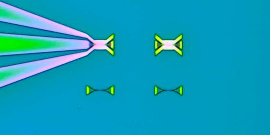 Mikroskopische Aufnahme eines Chips. Oben links: funktionsfähiger Modulator mit elektrischen Kontakten; rechts: Testmodulator ohne elektrischen Kontakt; unten: Testkomponenten.