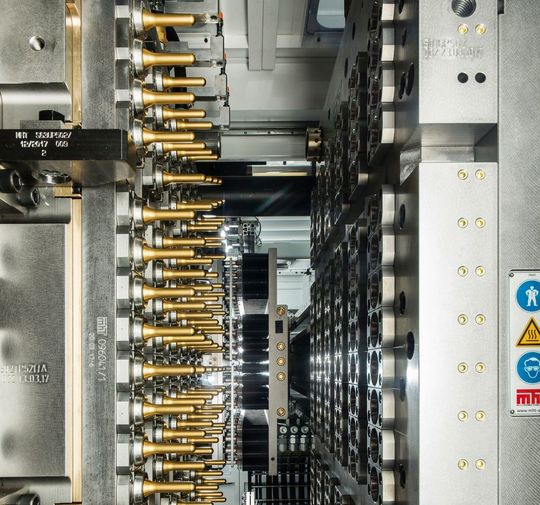 Alle 5 Sekunden liefert ein Werkzeug von MHT 92 reagenzglsartige PET-Peforms für die Flaschenproduktion im darauf folgenden Blasformprozess. Beschichtungs-Know-how von Oerlikon Balzers Coatings sorgt, wie hier auf den Kernen als golden glänzende Applikation zu erkennen, dafür, dass die Rasanz beim Spritzgießen stets gewährleistet ist. Alle 5 Sekunden liefert ein Werkzeug von MHT 92 reagenzglsartige PET-Peforms für die Flaschenproduktion im darauf folgenden Blasformprozess. Beschichtungs-Know-how von Oerlikon Balzers Coatings sorgt, wie hier auf den Kernen als golden glänzende Applikation zu erkennen, dafür, dass die Rasanz beim Spritzgießen stets gewährleistet ist.