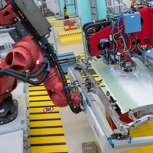 Die Vernietung von Stringern, Clips und Randträger mit der Außenhaut der Teilschalen erfolgt bei Premium Aerotec vollautomatisch in roboterbasierten Nietzellen. Die Vernietung von Stringern, Clips und Randträger mit der Außenhaut der Teilschalen erfolgt bei Premium Aerotec vollautomatisch in roboterbasierten Nietzellen.