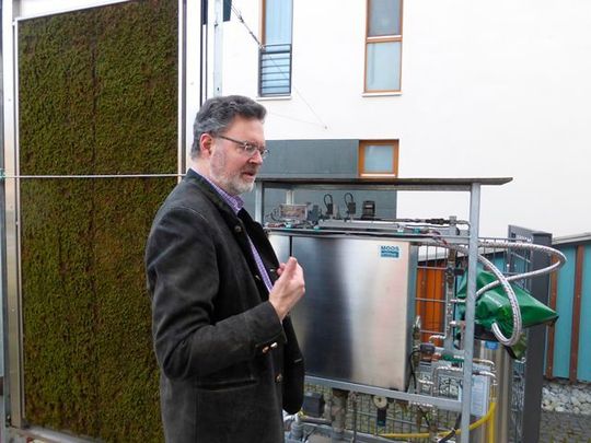 Dr. Günter Haese, Vorstand der Wohnungsgenossenschaft Gartenheim eG in Hannover, vor dem Prototyp der patentierten Moosmaschine.