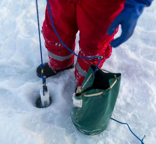 Ein Wissenschaftler nimmt eine Wasserprobe. Ein Wissenschaftler nimmt eine Wasserprobe.