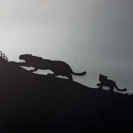 Beim Jaguar E-Pace schleicht in der schwarzen Umrandung der Windschutzscheibe ein stilisierter Jaguar mit Baby entlang. Beim Jaguar E-Pace schleicht in der schwarzen Umrandung der Windschutzscheibe ein stilisierter Jaguar mit Baby entlang.