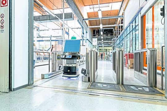 Eine Personensperre am Eingang zur Werkshalle erhöht die Sicherheit. Damit auch die FTS hier zügig durchkommen, kommunizieren sie mit der Personenkontrolle.