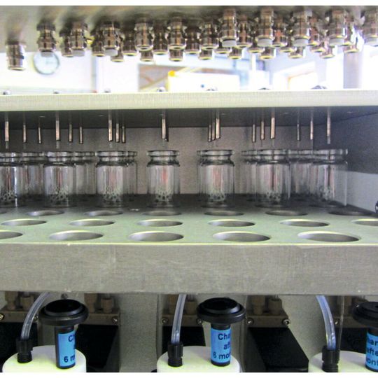 Abb. 1: Detailansicht des Racks mit den Vials und den einzelnen Dosierspitzen. Im Vordergrund sind vier Deckel von Vorlageflaschen mit den Durchführungen der Ansaugschläuche und den Belüftungsventilen zu erkennen. Abb. 1: Detailansicht des Racks mit den Vials und den einzelnen Dosierspitzen. Im Vordergrund sind vier Deckel von Vorlageflaschen mit den Durchführungen der Ansaugschläuche und den Belüftungsventilen zu erkennen.
