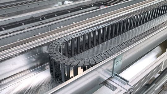 Durch den Einsatz von Edelstahlrinnen mit geringem Reibfaktor und Dämmschicht wird mit der Plane-E-Chain eine lange Lebensdauer und ein ruhiger Lauf erreicht.