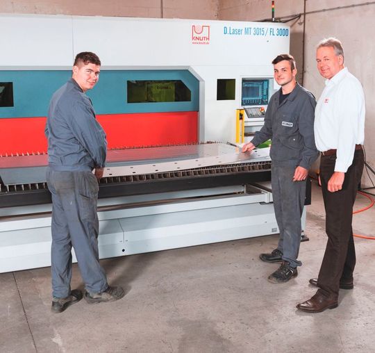 Knuth-Verkaufsleiter Christian Busch (rechts) mit zwei Kitzinger-Spezialisten, die Blechkomponenten aus der aktuellen Produktion präsentieren, die mit der D.Laser MT 3015/FL 3000 geschnitten wurden. Knuth-Verkaufsleiter Christian Busch (rechts) mit zwei Kitzinger-Spezialisten, die Blechkomponenten aus der aktuellen Produktion präsentieren, die mit der D.Laser MT 3015/FL 3000 geschnitten wurden.