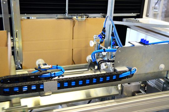 Per Druckluft wird der Karton ins Innere befördert und gedreht ...