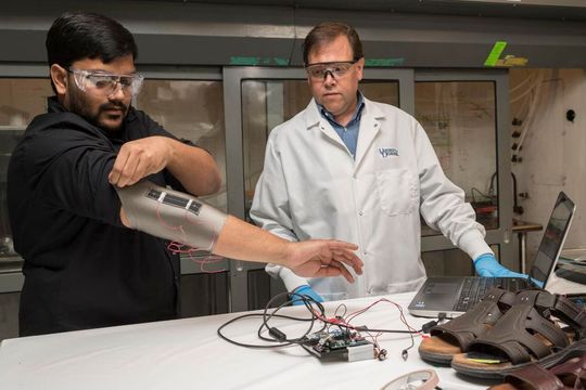 Sagar Doshi (links) und Erik Thostenson testen eine Ellbogenmanschette, die mit einem ihrer neuartigen Sensoren ausgestattet ist. Sagar Doshi (links) und Erik Thostenson testen eine Ellbogenmanschette, die mit einem ihrer neuartigen Sensoren ausgestattet ist.