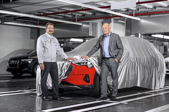 Peter Kössler (rechts), Produktionsvorstand der Audi AG und Patrick Danau, Geschäftsführer von Audi Brussels, stehen bei einem der ersten Serienmodelle des Audi E-Tron.