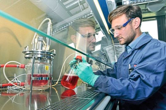 Alexander Nikolay bereitet im Max-Planck-Institut für Dynamik komplexer technischer Systeme einen Bioreaktor für einen Versuch vor. In einem Gefäß dieser Größe können die Forscher in ein paar Wochen genügend Viren für mehrere Millionen Dosen Impfstoff produzieren.