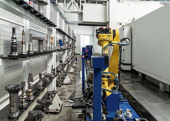 Werkzeugspeicher mit Werkzeugmanipulator, dem schienengeführten Werkzeugroboter und dem dahinter operierenden Shuttle-Pick-up