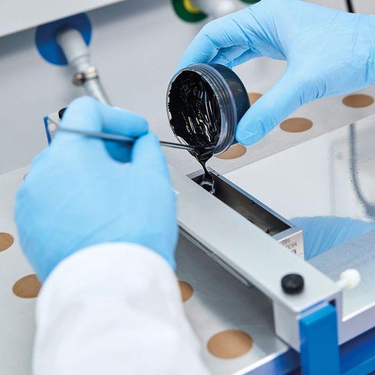 Für die Herstellung von kleinen Testbatterien gießt eine wissenschaftliche Mitarbeiterin von BASF eine Paste aus Kathodenmaterial auf eine Aluminiumfolie. Für die Herstellung von kleinen Testbatterien gießt eine wissenschaftliche Mitarbeiterin von BASF eine Paste aus Kathodenmaterial auf eine Aluminiumfolie.
