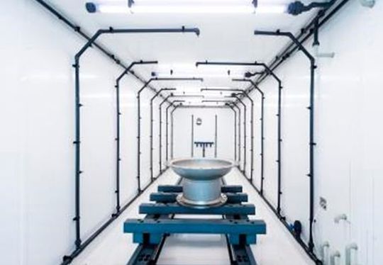 Blick in die Rotainer-Beizanlage von Siedentop: Im geschlossenen Container-System werden die Bauteile mit Tauchbeize besprüht.