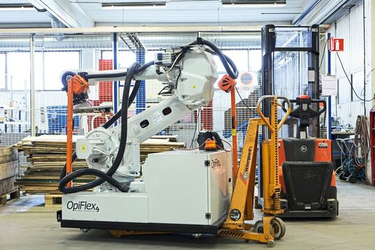 Sofort einsatzbereit: Mit einem Flurförderzeug wird der mobile Roboter von Opiflex in einer Produktion zur passenden Arbeitsstation gefahren, dort fest an einer vorher installierten Plattform angedockt und eingesteckt.