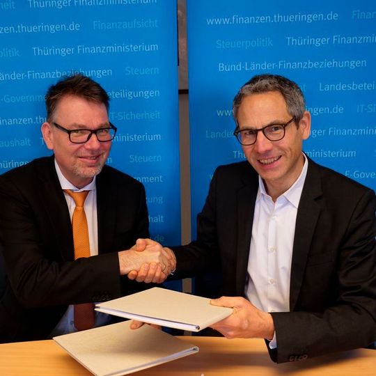 Hartmut Schubert (Thüringer Finanzministerium) und Roland Adrian (Verimi) unterzeichneten die Verträge zur Nutzung des Verimi-Log-in in Thüringen. Hartmut Schubert (Thüringer Finanzministerium) und Roland Adrian (Verimi) unterzeichneten die Verträge zur Nutzung des Verimi-Log-in in Thüringen.
