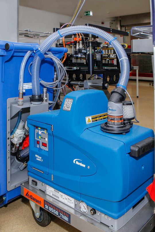 Das – in diesem Fall auf ein Rollengestell montierte – Hotmelt-Auftragssystem ProBlue Liberty 7, das direkt aus einem groß dimensionierten Vorratsbehälter mit Granulat versorgt wird.