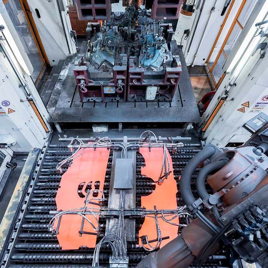 Um Platinen in Form zu bringen, werden sie in einem Ofen erhitzt. Rotglühend laufen sie in die Presse und werden dort im geschlossenen Werkzeug abgekühlt und zum Bauteil umgeformt.