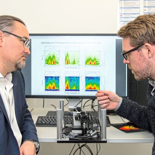 (v.l.) Prof. Dr. Juergen Hauer und Erstautor Erling Thyrhaug mit ihrem Messinstrument. Im Hintergrund Spektren, die damit aufgenommen wurden. (v.l.) Prof. Dr. Juergen Hauer und Erstautor Erling Thyrhaug mit ihrem Messinstrument. Im Hintergrund Spektren, die damit aufgenommen wurden.