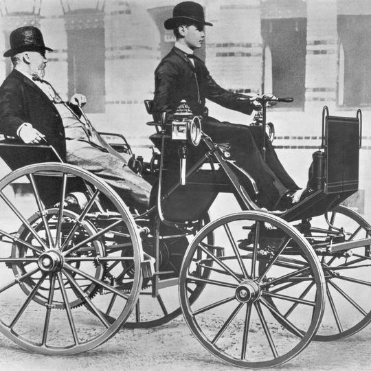 Gottlieb Daimler (17. März 1834 bis 6. März 1900) in seiner Motorkutsche von 1886, dem ersten vierrädrigen Benzinautomobil der Welt. Am Steuer Daimlers Sohn Adolf (1871-1913). Gottlieb Daimler (17. März 1834 bis 6. März 1900) in seiner Motorkutsche von 1886, dem ersten vierrädrigen Benzinautomobil der Welt. Am Steuer Daimlers Sohn Adolf (1871-1913).