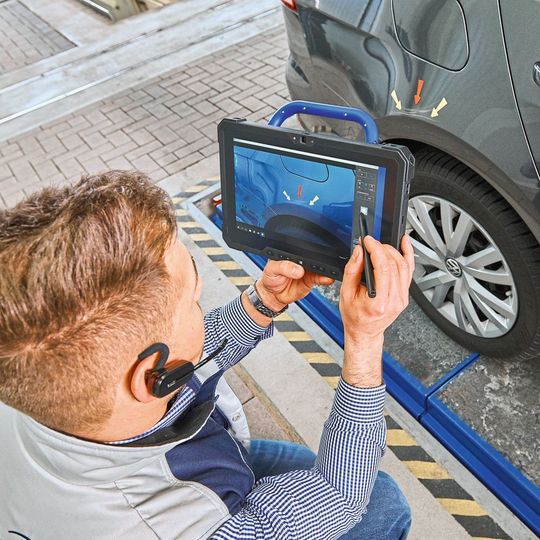 Der Ingenieur in der Werkstatt nimmt den Schaden mit Digitalkamera, Tablet oder Smartphone auf und ist dabei über einen Livestream direkt mit einem Gutachter im Sachverständigenzentrum verbunden. Der Ingenieur in der Werkstatt nimmt den Schaden mit Digitalkamera, Tablet oder Smartphone auf und ist dabei über einen Livestream direkt mit einem Gutachter im Sachverständigenzentrum verbunden.