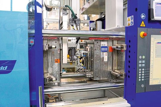 Bild 4: Beide Wittmann-Battenfeld-Spritzgießmaschinen sind mit Rolle-zu-Rolle-Folienvorschubeinheiten ausgerüstet. Die Roboter tragen dabei eine Folienwärmeplatte und gegenüber dieser den Sauggreifer zur Fertigteilentnahme. Bild 4: Beide Wittmann-Battenfeld-Spritzgießmaschinen sind mit Rolle-zu-Rolle-Folienvorschubeinheiten ausgerüstet. Die Roboter tragen dabei eine Folienwärmeplatte und gegenüber dieser den Sauggreifer zur Fertigteilentnahme.