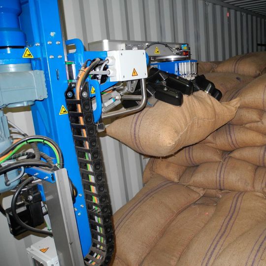 Das System von Copal greift die Kaffeesäcke automatisch und befördert sie über ein Förderband weiter. Das System von Copal greift die Kaffeesäcke automatisch und befördert sie über ein Förderband weiter.
