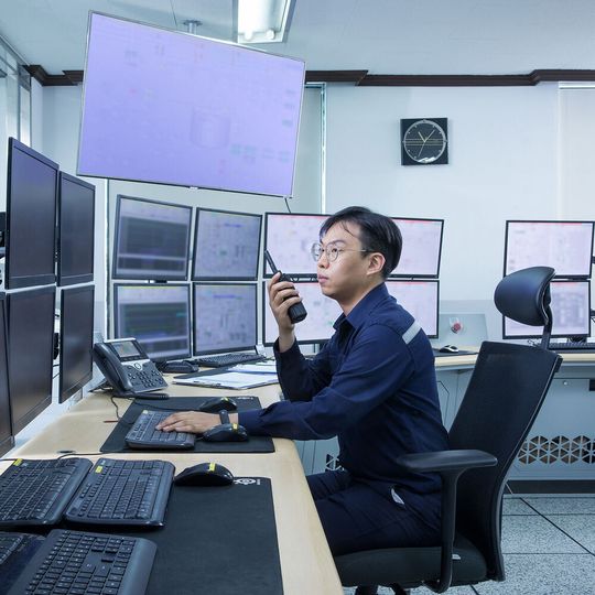 An operator monitors production in the control room. An operator monitors production in the control room.